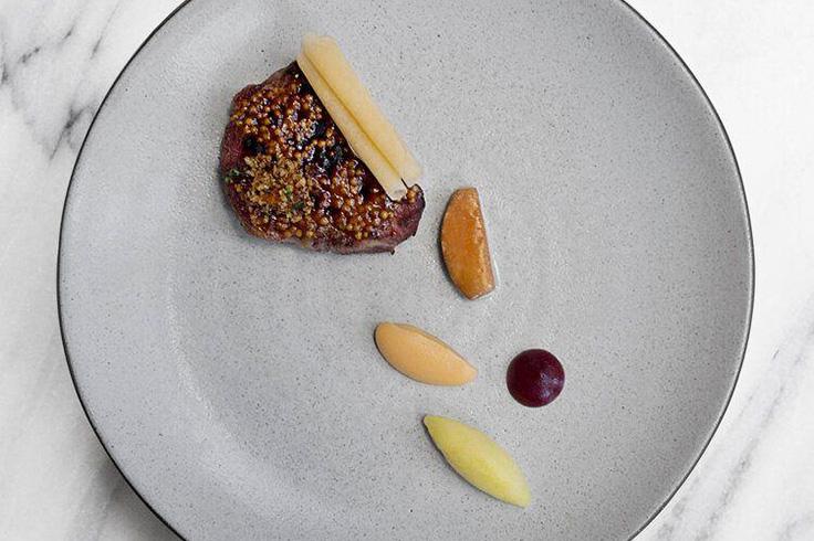 Aquavit's pork neck with rutabaga purée, wine pickled plums, peppery crumble and pearl barley. (Photo courtesy of Aquavit/Facebook.)