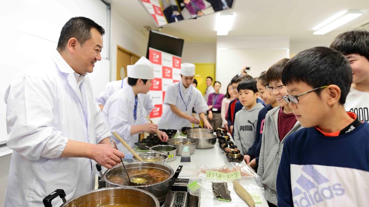 Chef Toru Okuda preparing healthy lunch dishes at a school in Japan