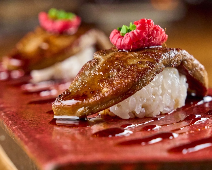 A zoomed in look at 99 Sushi Bar's '99 Grilled Foie' nigiri, topped with raspberry and tare sauce. Image credit: 99 Sushi Bar