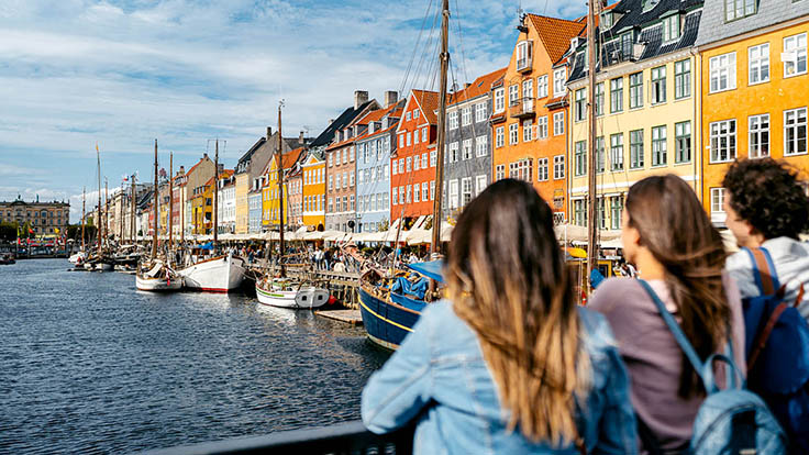 Visitors look out onto Copenhagen's Nyhavn Canal. © urbazon/iStock